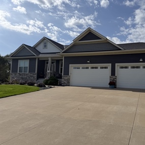 Insulated garage door installation on a residential home in Ham Lake, MN, featuring two white garage doors.